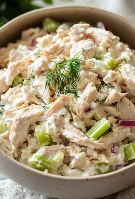 Delicious chicken salad served in a bowl with fresh vegetables and herbs