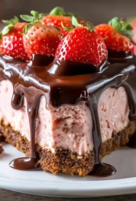 Slice of chocolate covered strawberry cheesecake topped with fresh strawberries
