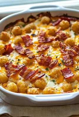 Delicious cracked out tater tot breakfast casserole topped with crispy bacon and cheese