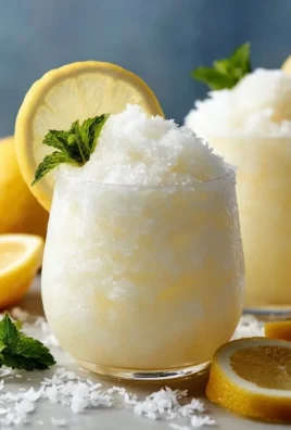 Creamy frozen coconut lemonade served in a chilled glass with a lemon slice garnish.