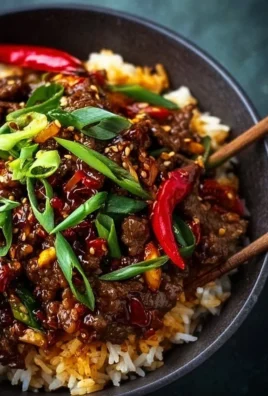 Plate of Crispy Chilli Beef Rice garnished with fresh herbs