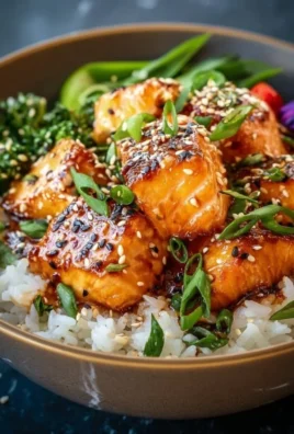 Crispy Salmon served in a rice bowl with fresh vegetables and sauces