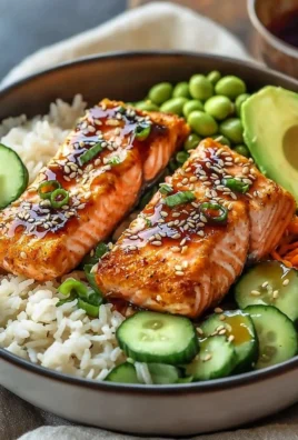 Crispy salmon on a bed of rice in a vibrant bowl, garnished with vegetables.