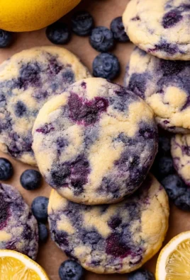 Lemon blueberry cheesecake cookies with a creamy filling and fresh berries