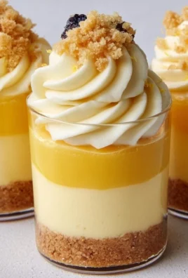 Lemon curd cheesecake dessert cups topped with fresh lemon zest and berries