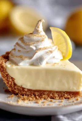 Slice of Magnolia Lemon Pie topped with whipped cream and fresh lemon zest