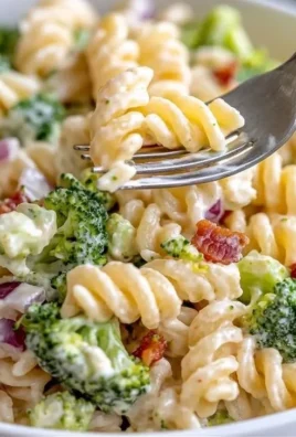 A vibrant bowl of broccoli pasta salad featuring fresh vegetables and dressing.