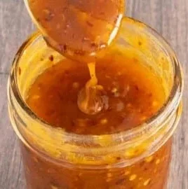 Delicious homemade hot honey in a jar with chili peppers and honeycomb