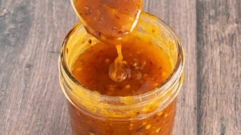Delicious homemade hot honey in a jar with chili peppers and honeycomb