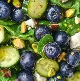 Delicious blueberry pistachio spring salad with fresh greens and colorful fruits