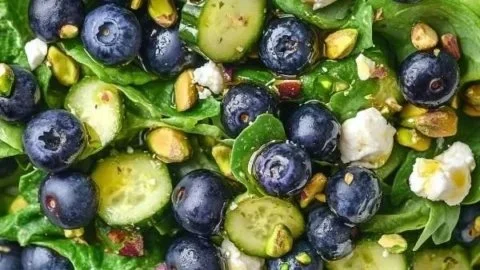 Delicious blueberry pistachio spring salad with fresh greens and colorful fruits