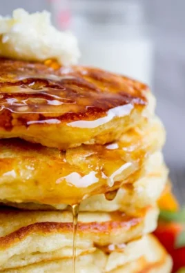 Stack of fluffy buttermilk pancakes with syrup and berries