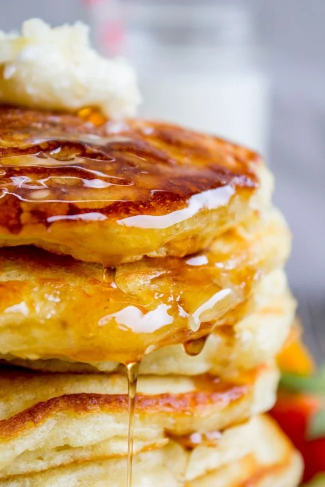 Stack of fluffy buttermilk pancakes with syrup and berries