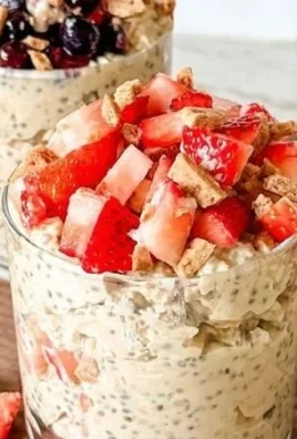 Bowl of cheesecake overnight oats topped with berries and nuts
