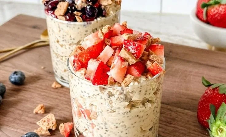 Bowl of cheesecake overnight oats topped with berries and nuts