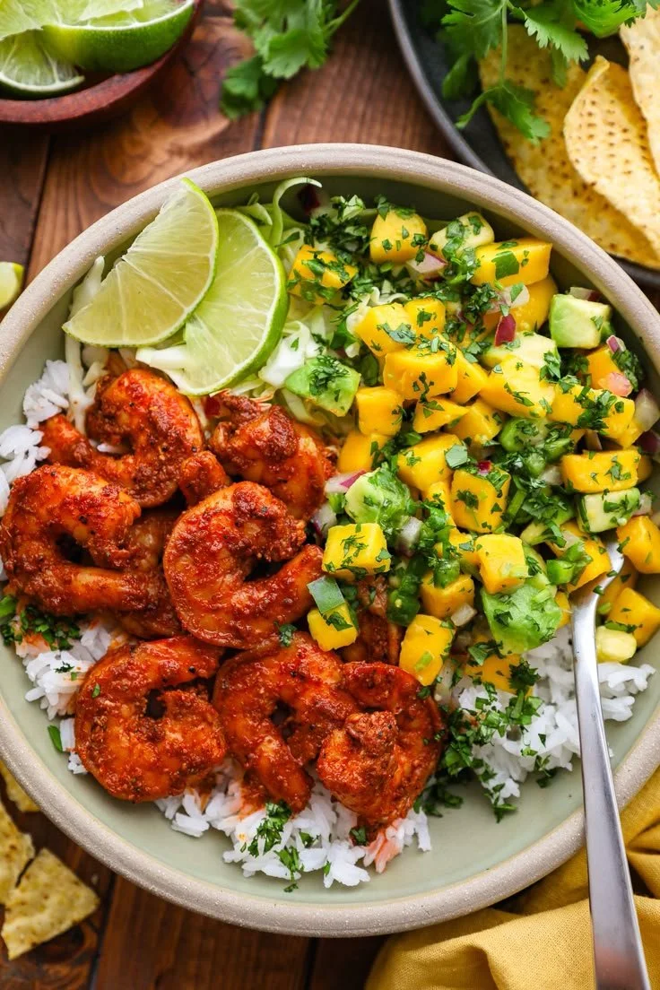 Chili lime shrimp bowls with mango-avocado salsa served in a white bowl.