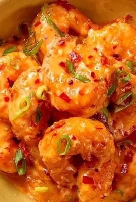 Delicious classic Bang Bang Shrimp served in a bowl, garnished with green onions.