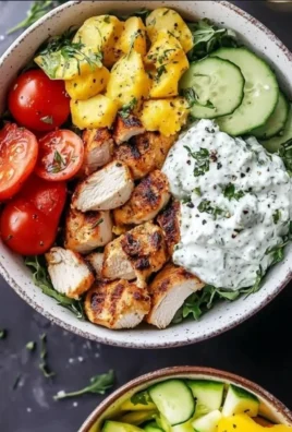 Delicious easy loaded Greek chicken bowl with fresh vegetables and herbs