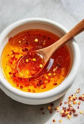Bottle of Garlic Hot Honey with garlic cloves and chili peppers
