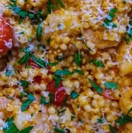 Harissa shrimp served over fluffy couscous, garnished with fresh herbs.