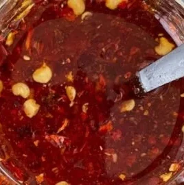 A bottle of hot honey drizzled over a dish, showcasing its sweet and spicy flavor.
