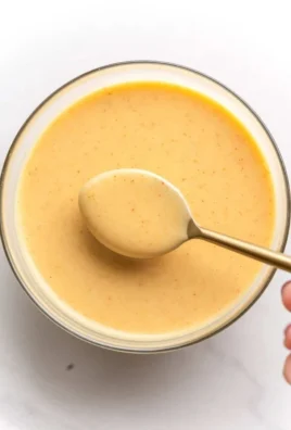 Delicious hot honey dipping sauce in a bowl with a honey dipper