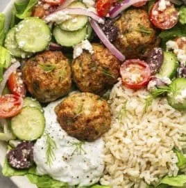 Mediterranean chicken meatball bowls topped with fresh herbs and vegetables