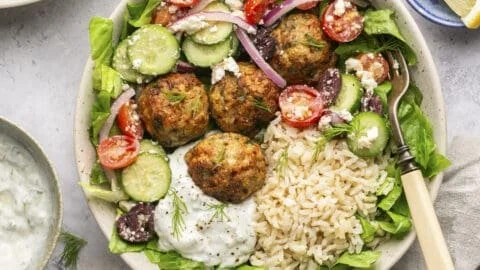 Mediterranean chicken meatball bowls topped with fresh herbs and vegetables