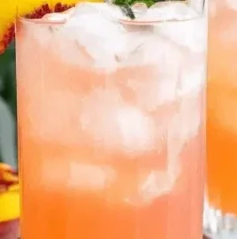 Refreshing glass of Peach Lemonade with fresh peaches and lemons
