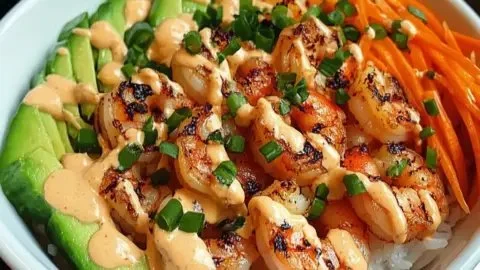 Shrimp rice bowls garnished with spicy mayo and fresh vegetables