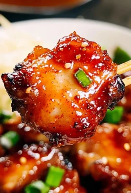 Sticky sweet chili chicken dish garnished with herbs