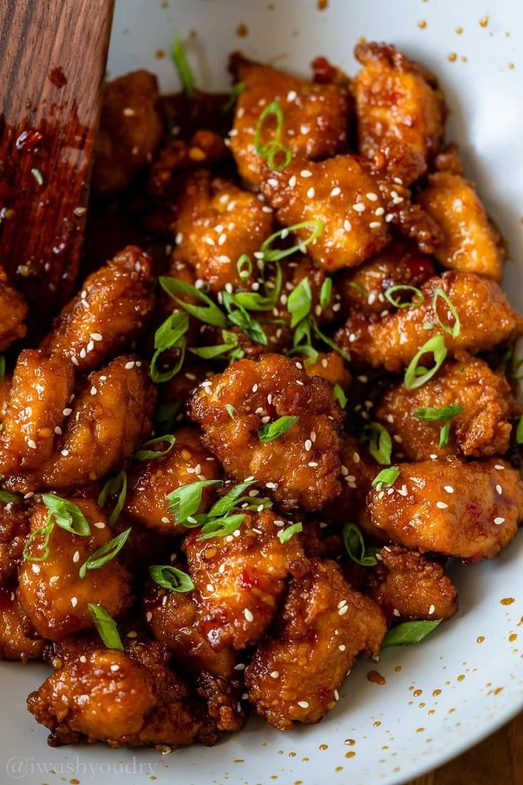 Plate of Sweet Chili Chicken garnished with herbs and served with rice