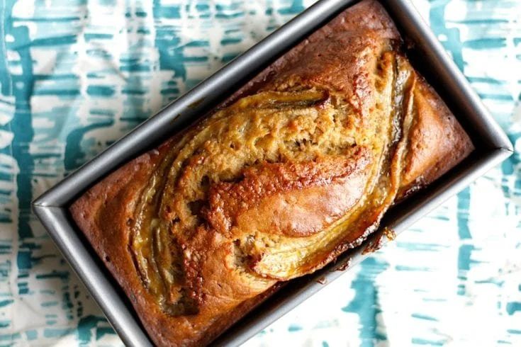 Slice of brown-butter banana bread on a white plate.
