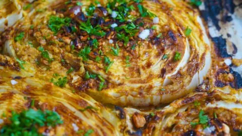 Oven-roasted cabbage steaks served with herbs and spices