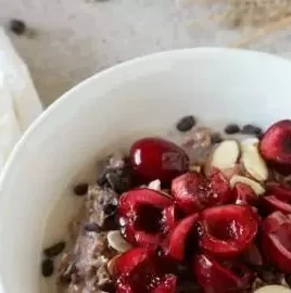Chocolate cherry overnight oats in a bowl topped with fresh cherries and chocolate shavings