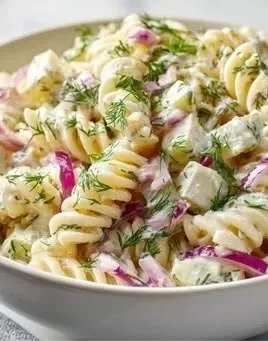 Creamy dill pickle pasta salad served in a bowl with fresh herbs