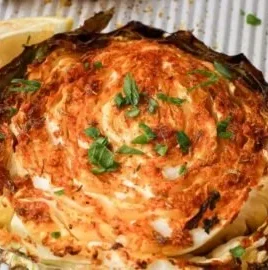 Oven roasted cabbage steaks topped with spices, served on a plate