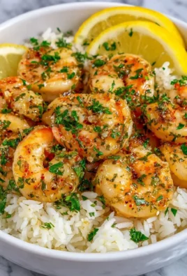 Delicious garlic butter shrimp rice served in a bowl with herbs and lemon.