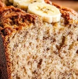 Healthy Greek yogurt banana bread slice on a plate with ripe bananas