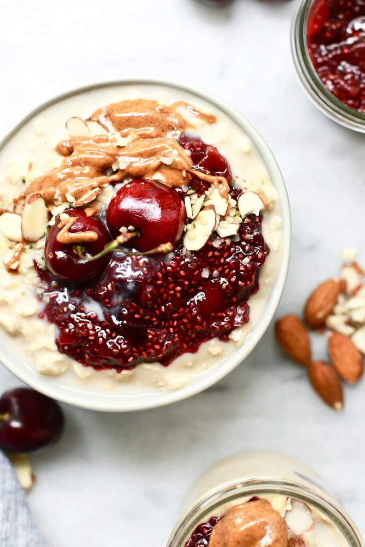 Healthy overnight oats with cherry chia seed jam in a glass bowl