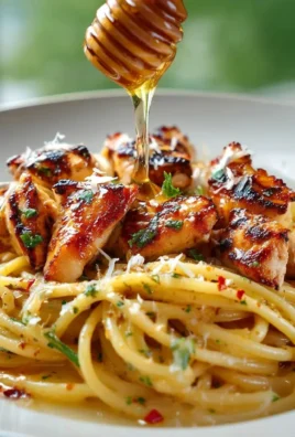 Delicious hot honey chicken pasta served in a bowl with creamy sauce and herbs.