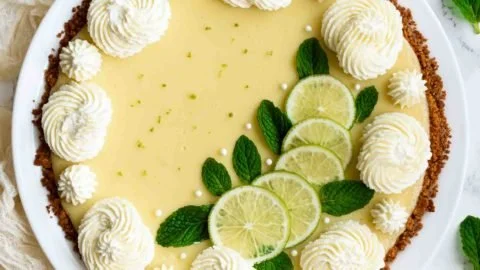 Delicious slice of Key Lime Pie with lime garnish on a white plate