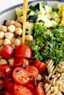 Mediterranean Chickpea Pasta Salad with fresh vegetables and dressing.