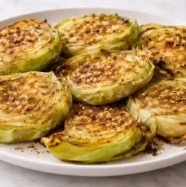 Oven roasted garlic cabbage steaks served on a plate with herbs and spices