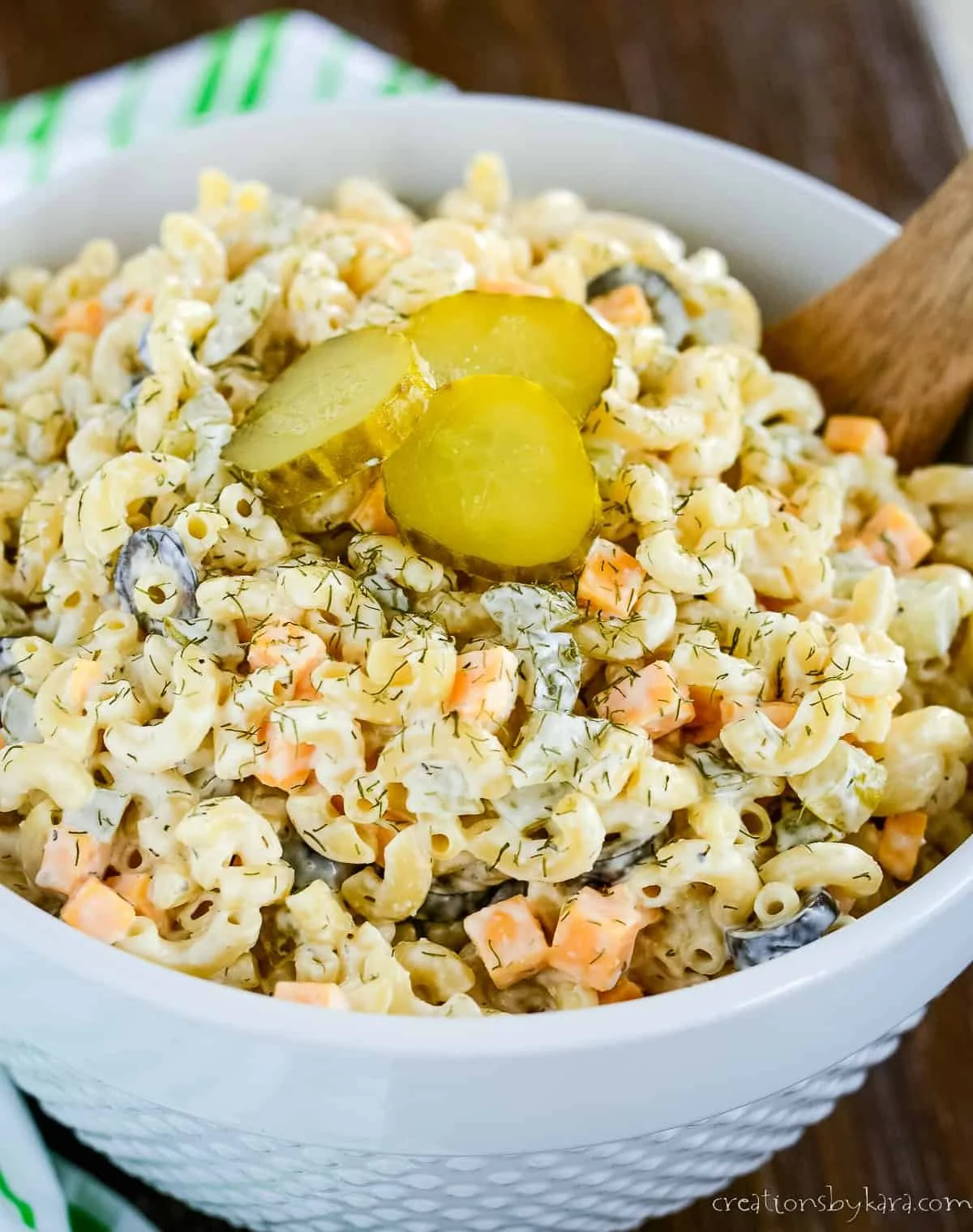 Pasta salad with dill pickles, vegetables, and dressing in a bowl