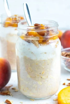 Bowl of Peach Cobbler Overnight Oats topped with fresh peaches and spices