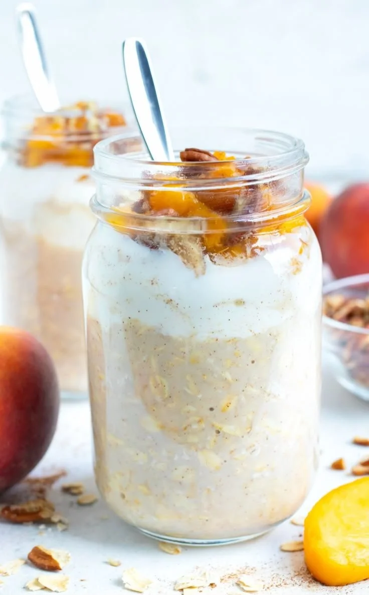 Bowl of Peach Cobbler Overnight Oats topped with fresh peaches and spices