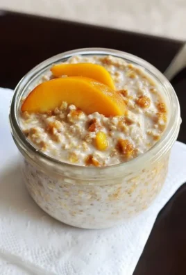 Delicious Peach Overnight Oats topped with fresh peach slices and nuts.