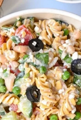 Healthy protein-packed pasta salad with vegetables and dressing