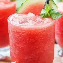 Refreshing watermelon slushie served in a glass with ice and mint leaves